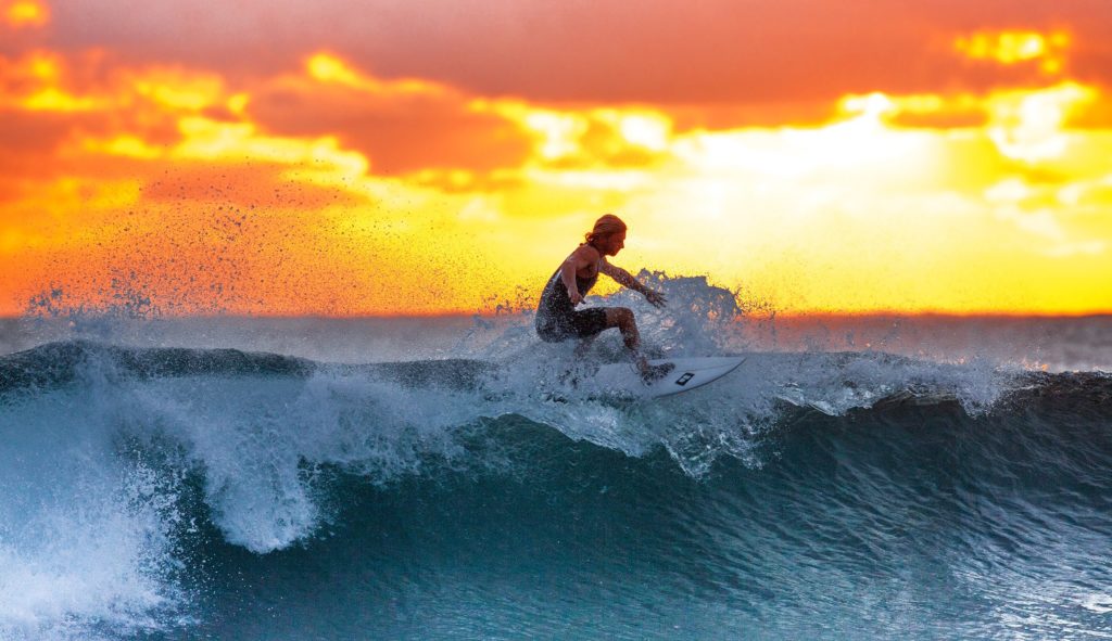 Man surfing waves at sunset.