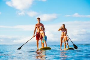 Ocean-bound, a family of four on paddle boards, embodying the essence of a surf family.