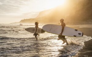  A pair of surfers confidently make their way towards the ocean, surfboards in hand, prepared for an exhilarating ride on the waves.
