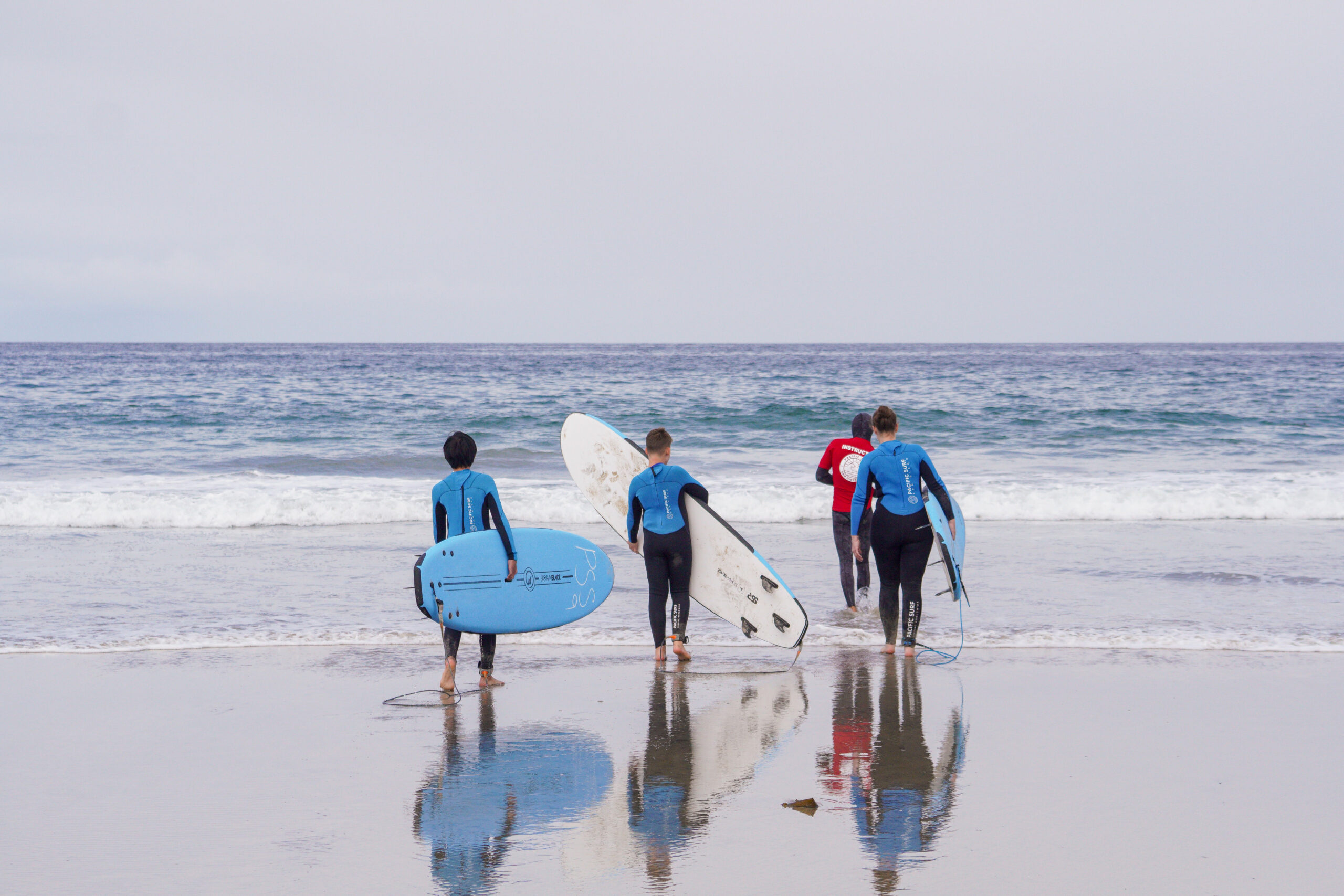 Group of student surfers heading towards the sea
